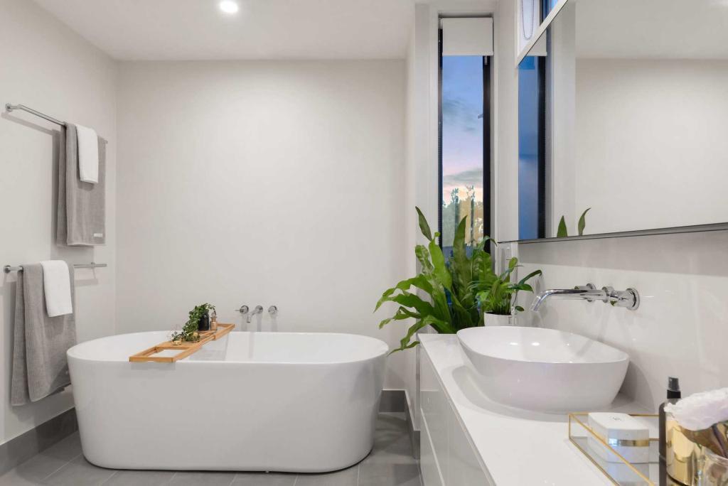 A modern bathroom with a white tub and vanity.