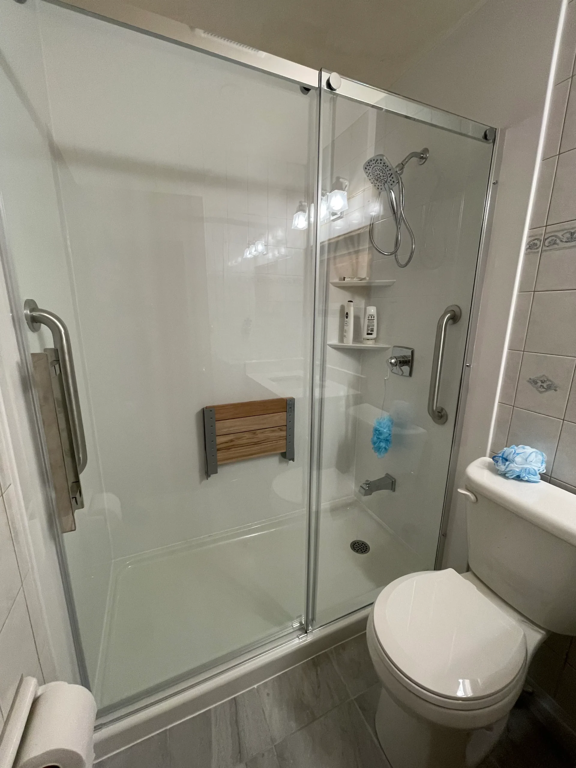 an image about A bathroom with a glass shower stall and acrylic panels.