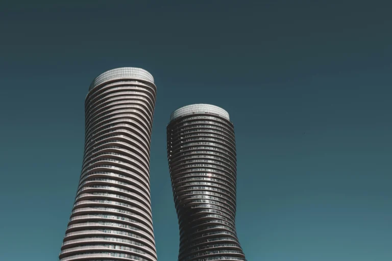 an image about Two tall buildings in Mississauga with a blue sky behind them.