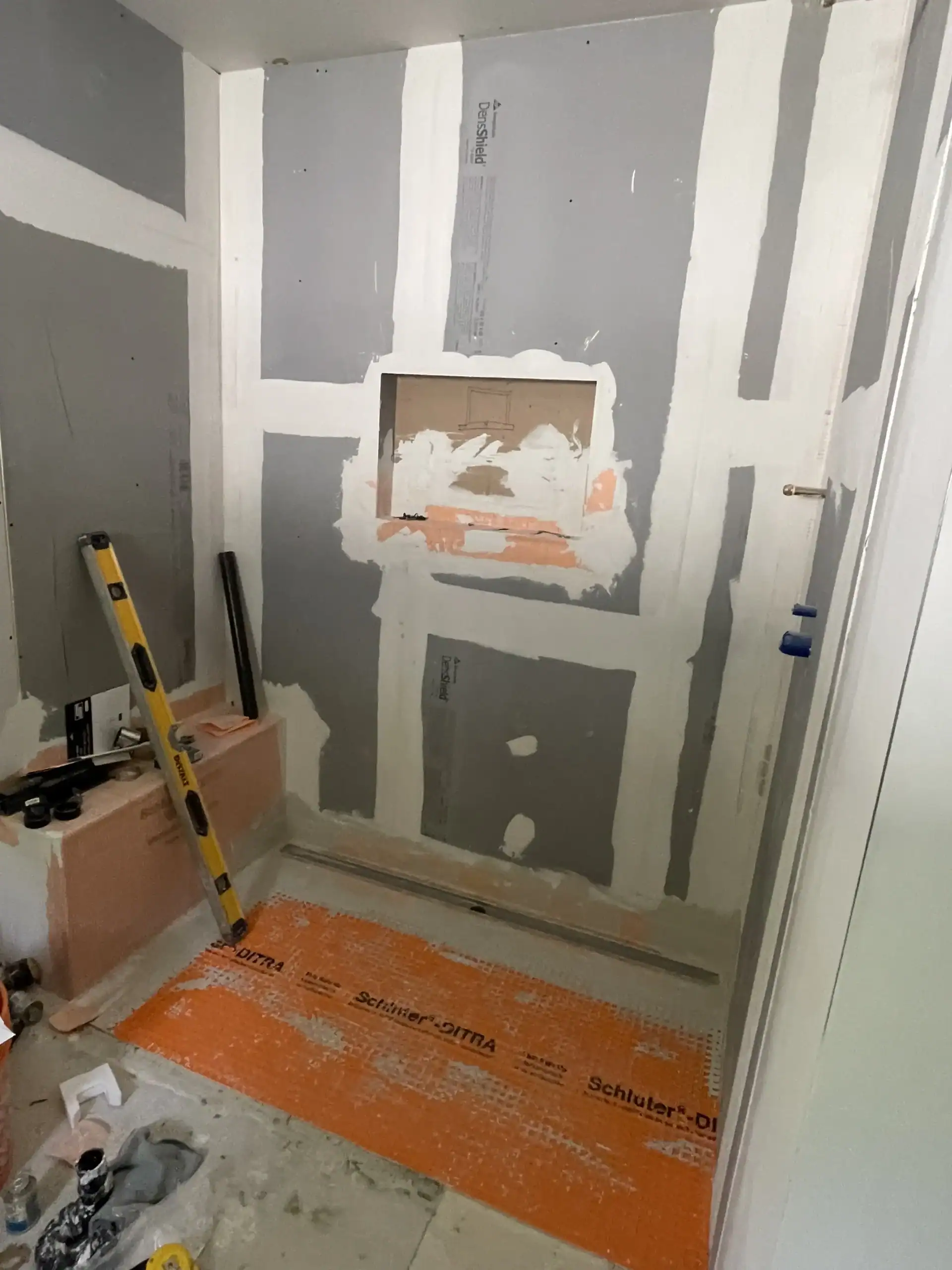 Schluter DITRA waterproofing membrane being installed on shower floor during professional bathroom renovation in Toronto