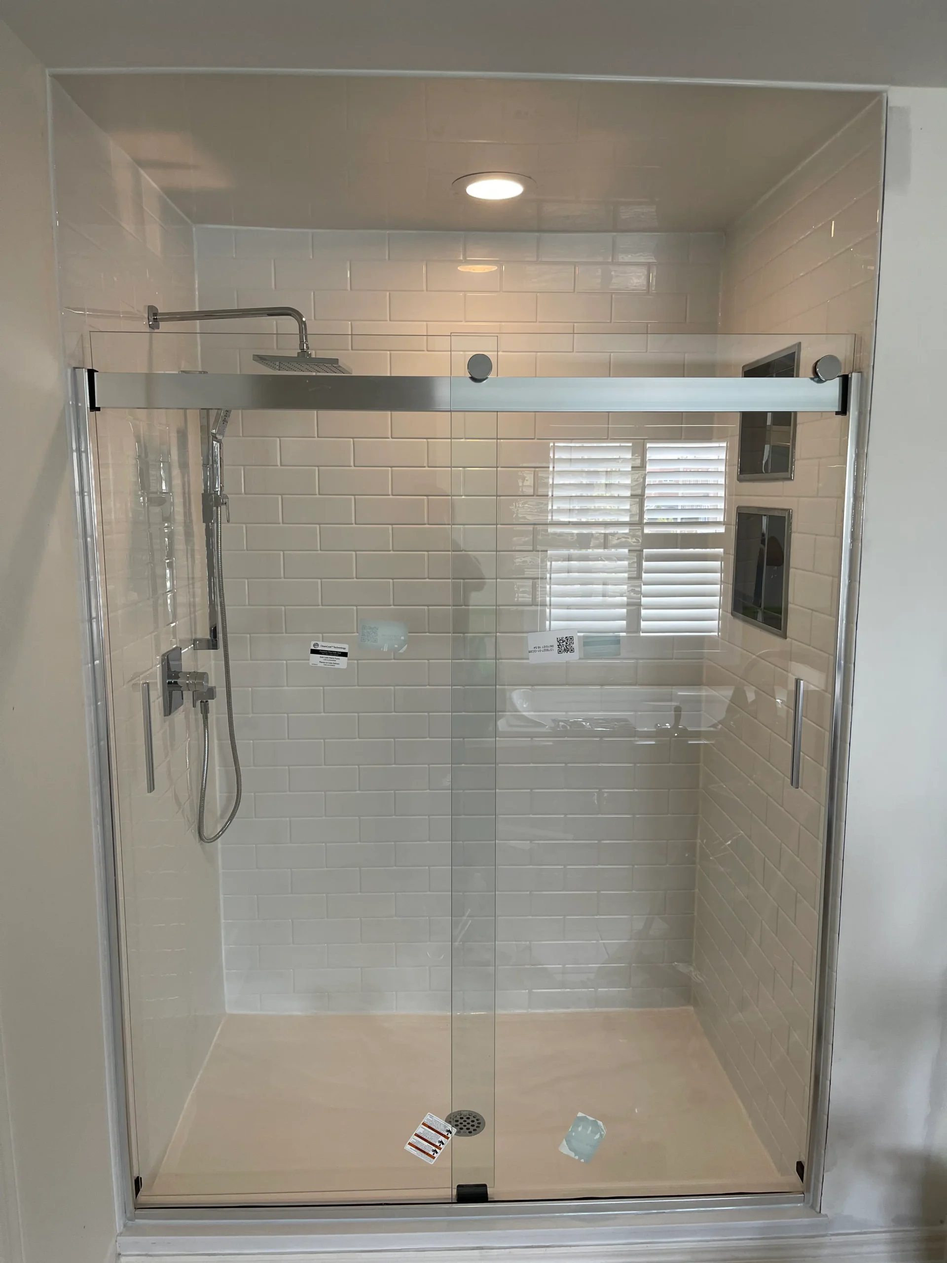 an image about A glass shower door in a bathroom, featuring bathroom acrylic panels.