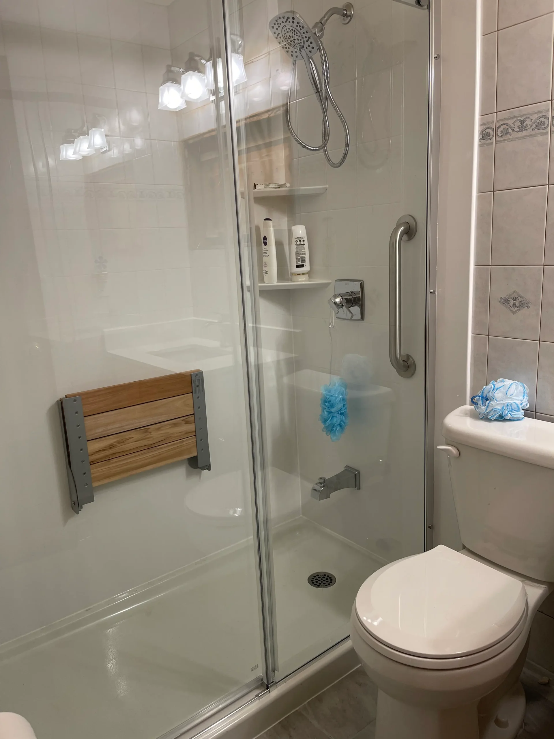 an image about A bathroom with a glass shower stall and acrylic panels for the walls.